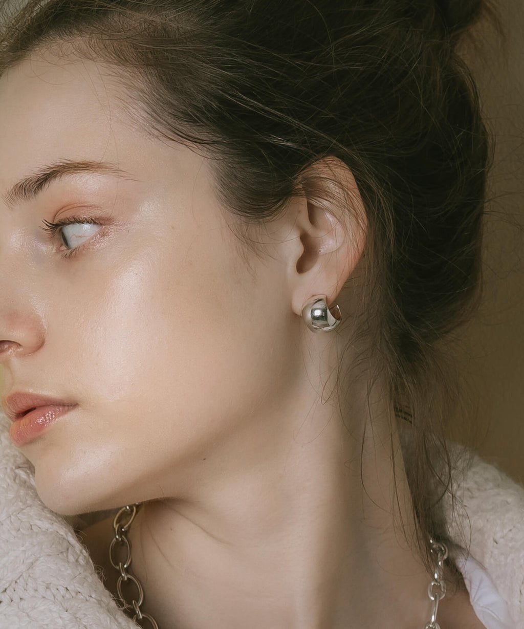 High-polish silver statement earrings, side profile