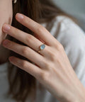 Milky aquamarine cabochon ring in 10K gold worn on the hand