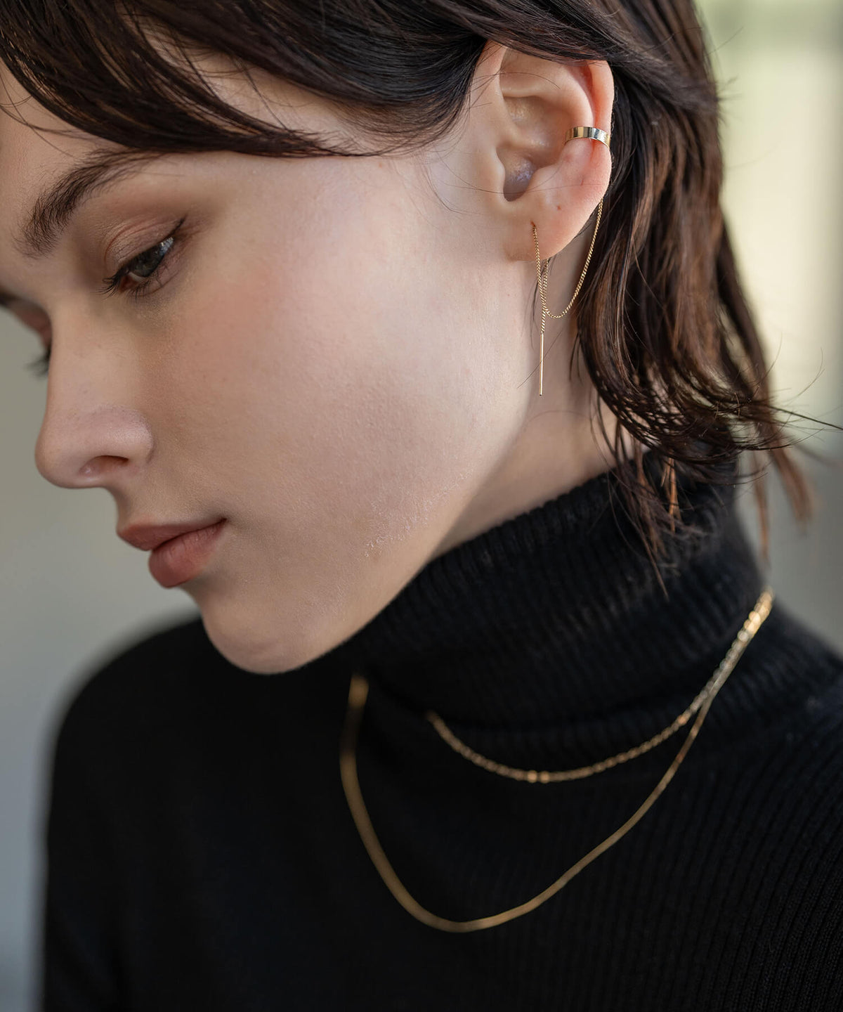 Close up of the 10K gold chain draping from the ear cuff to the lobe
