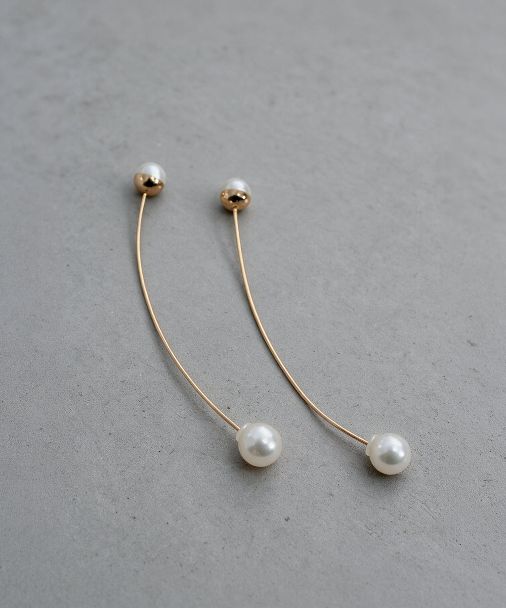 18K pink gold long pearl swing earrings ILMARI on concrete
