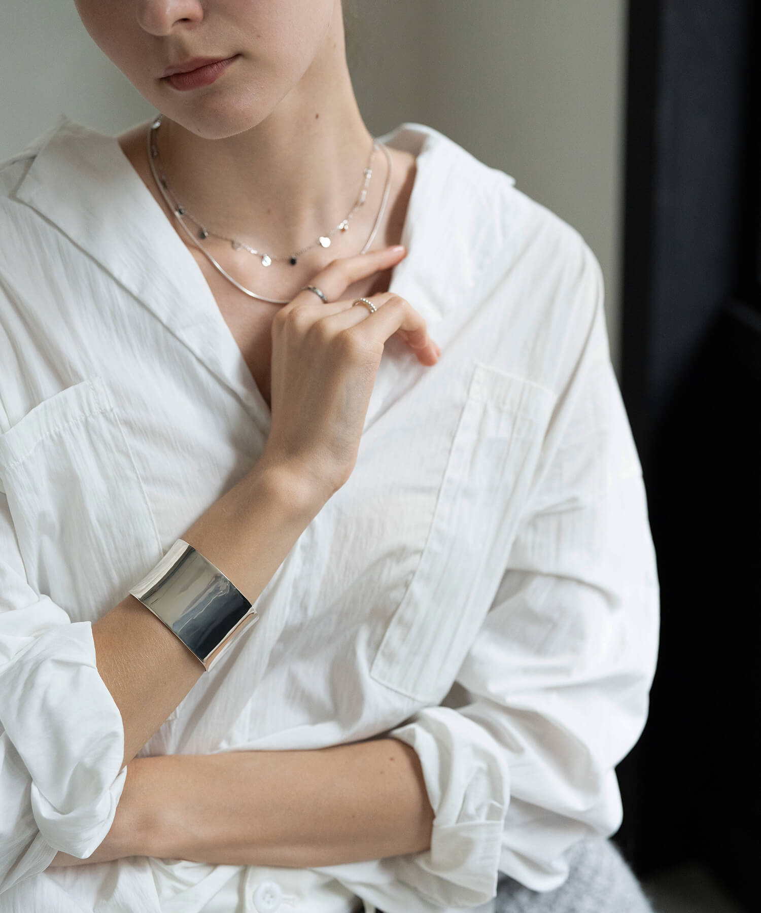 Broad straight silver bangle on the wrist, side view