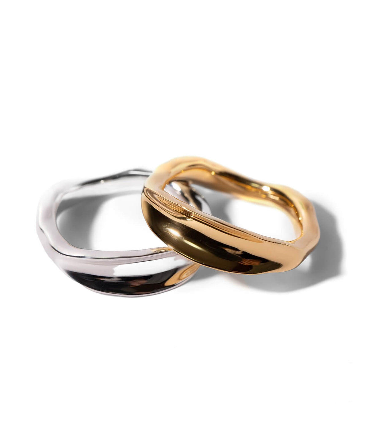 Silver and gold ripple wave rings on a white background