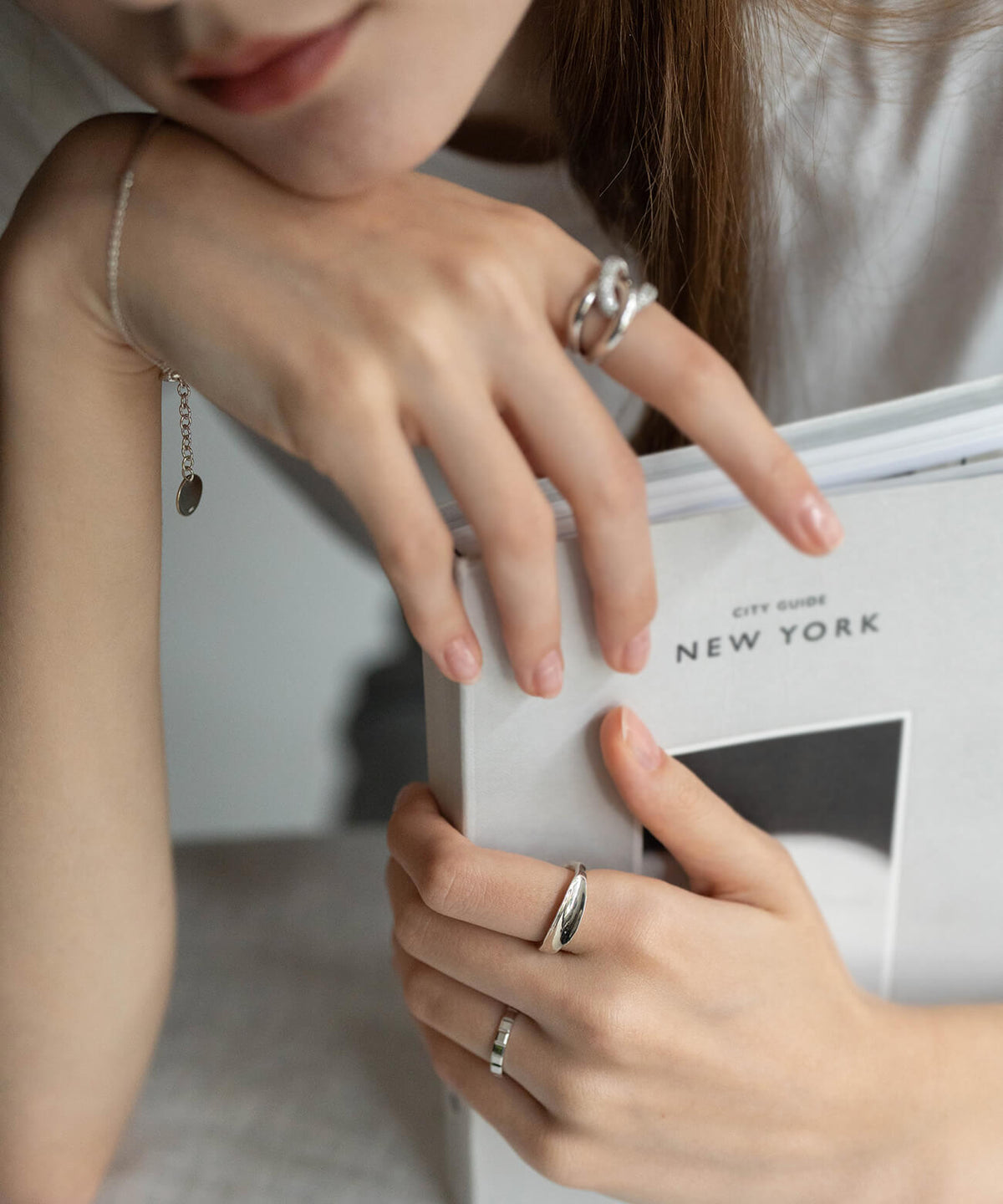 Hands holding a book, wearing the sterling silver ripple wave ring