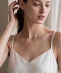 18K gold petit grain necklace worn at the neckline