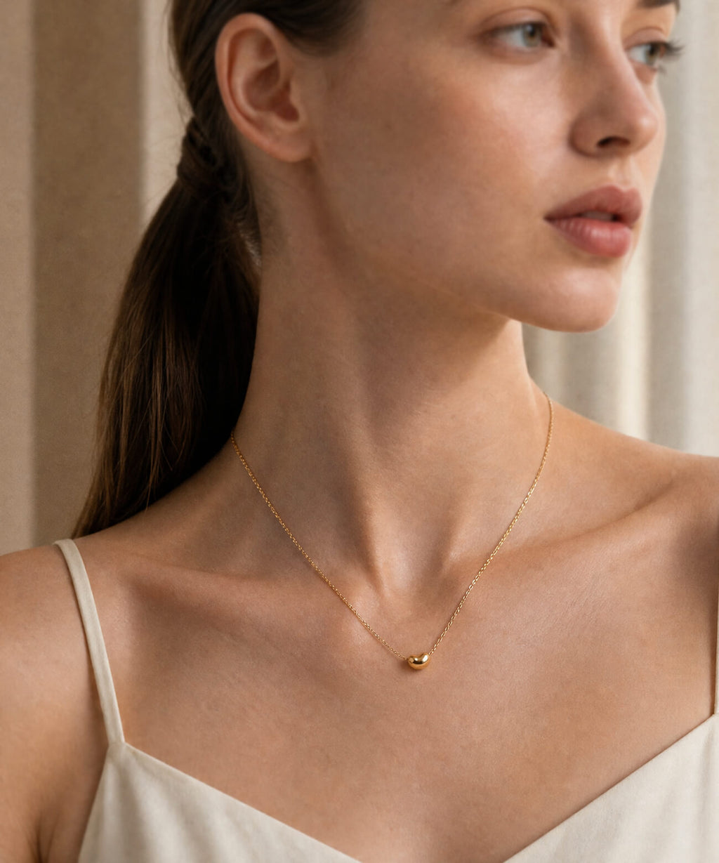 18K gold fave bean pendant necklace worn close up