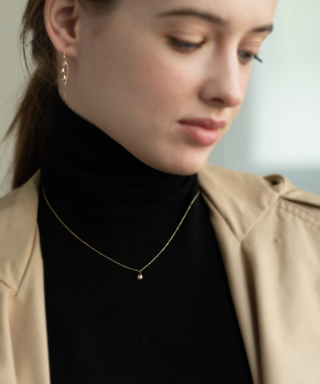 18K gold egg pendant necklace worn close up