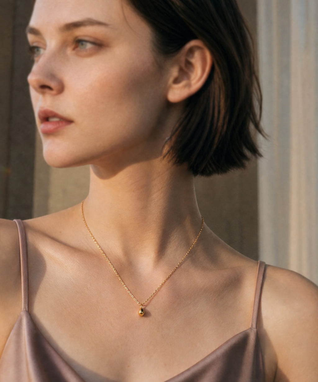 18K gold egg pendant necklace styled on a model