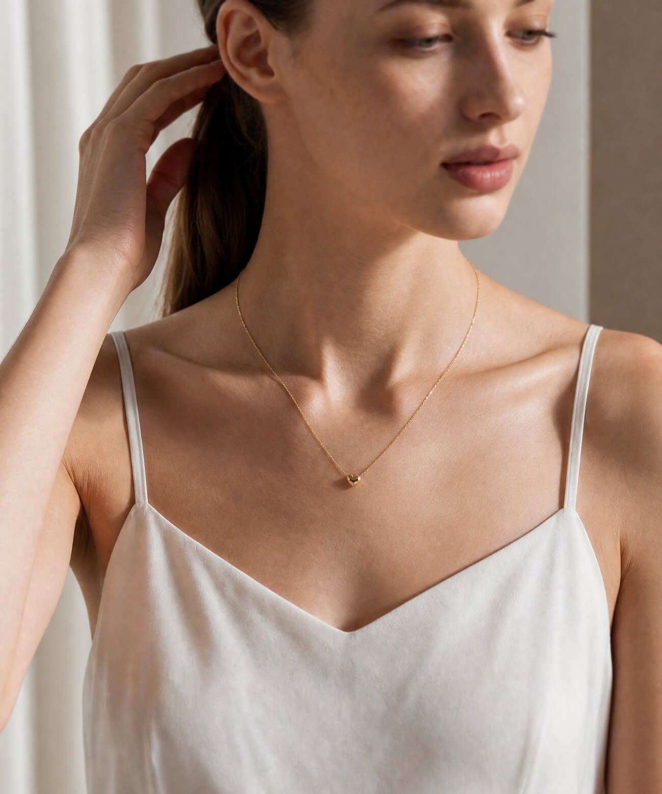 18K gold heart pendant necklace worn close up