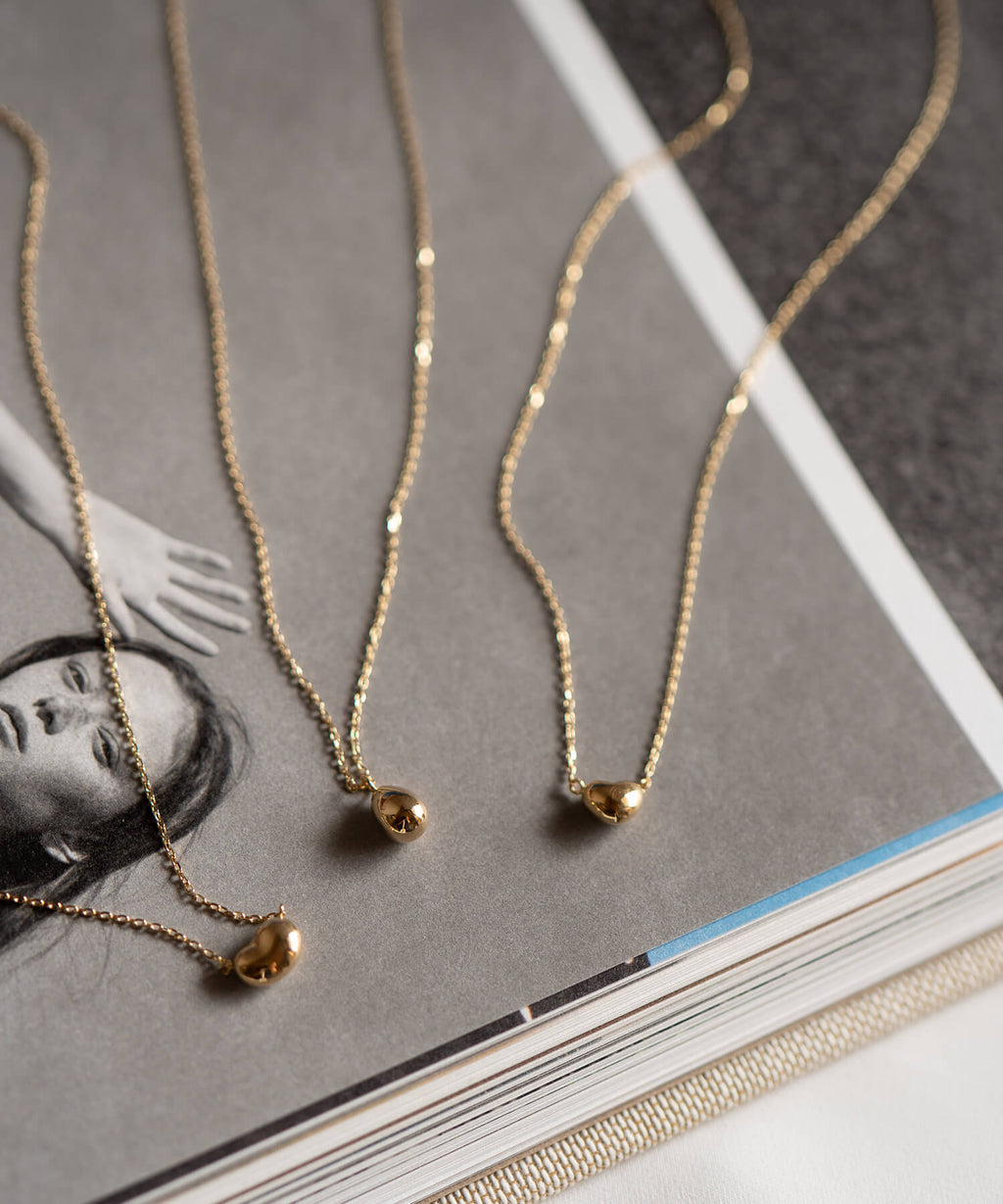18K gold petit grain necklace worn with everyday styling