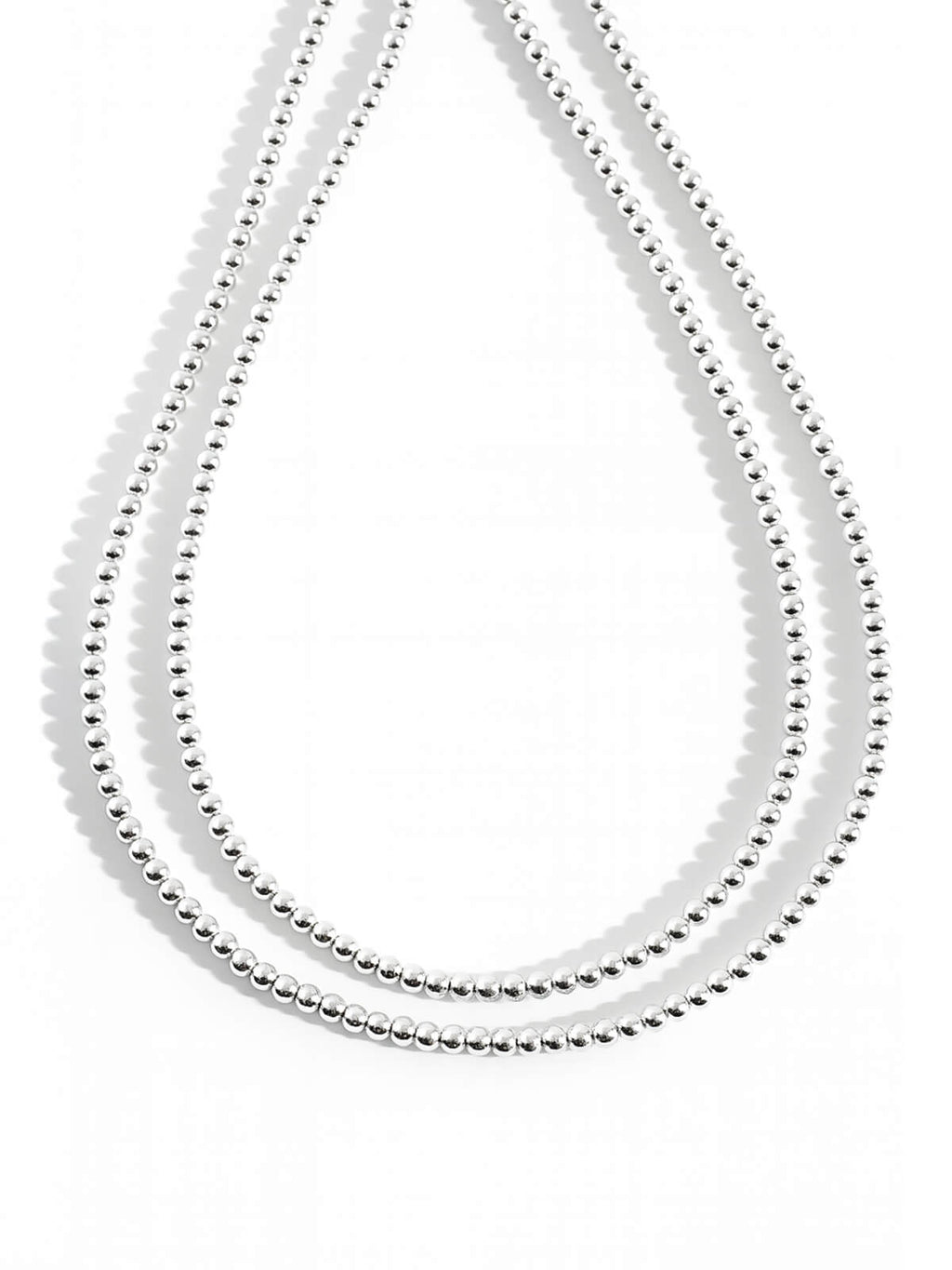 Sterling silver 4mm ball chain long necklace doubled on a white background