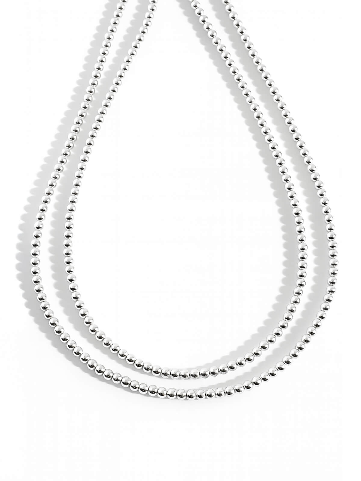 Sterling silver 4mm ball chain long necklace doubled on a white background