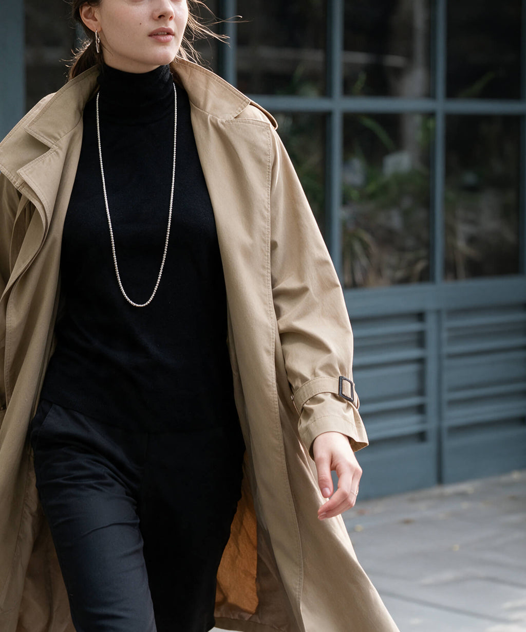 Sterling silver 4mm ball chain long necklace worn with a trench coat and black turtleneck