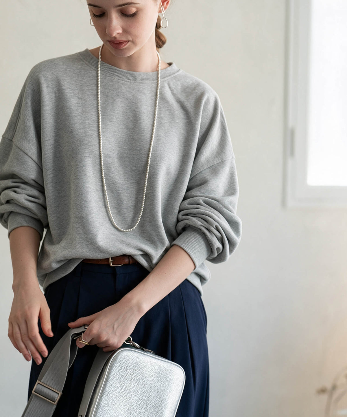 Long silver ball chain necklace with a grey sweatshirt and navy skirt