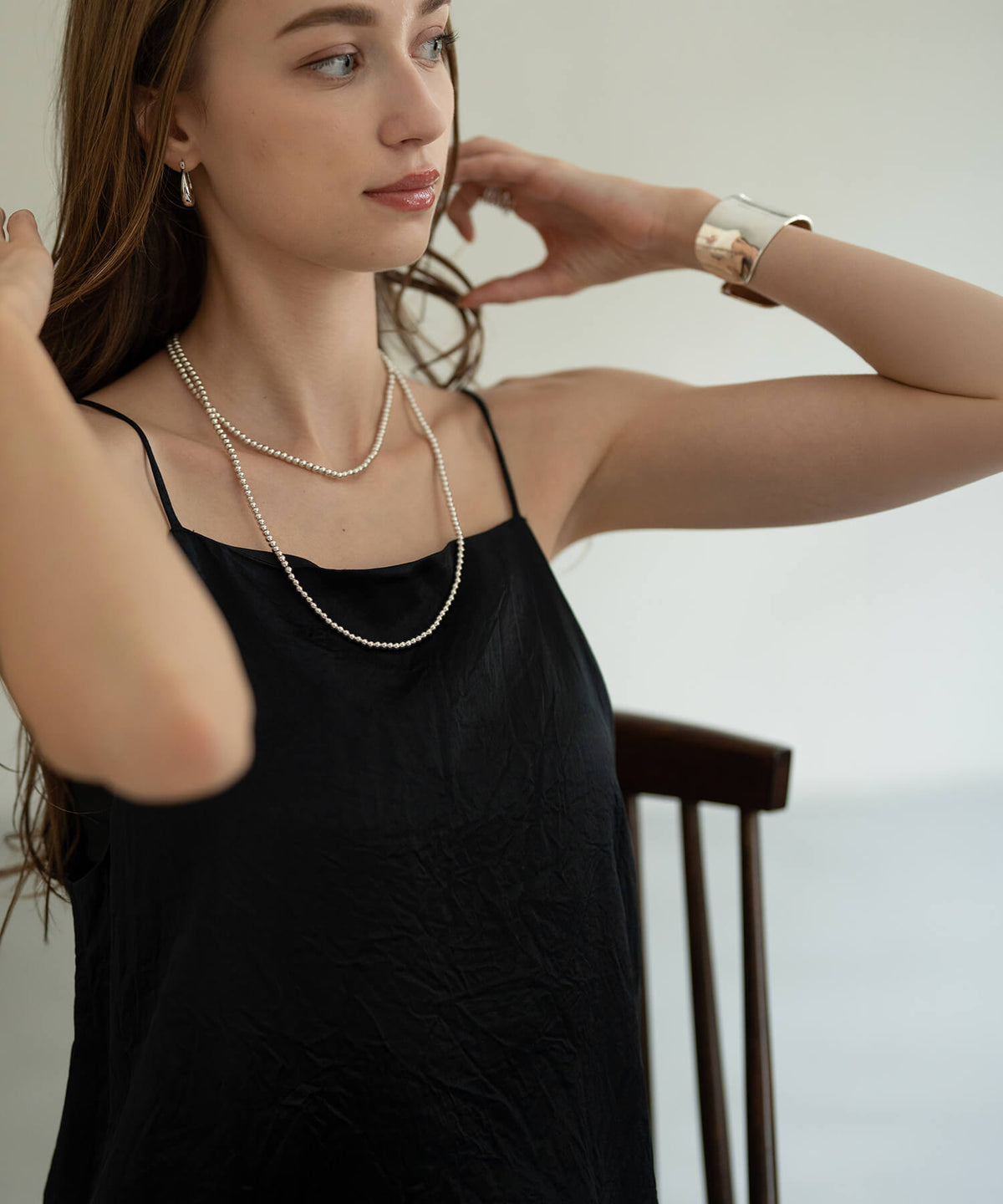 Long silver ball chain necklace with a black camisole