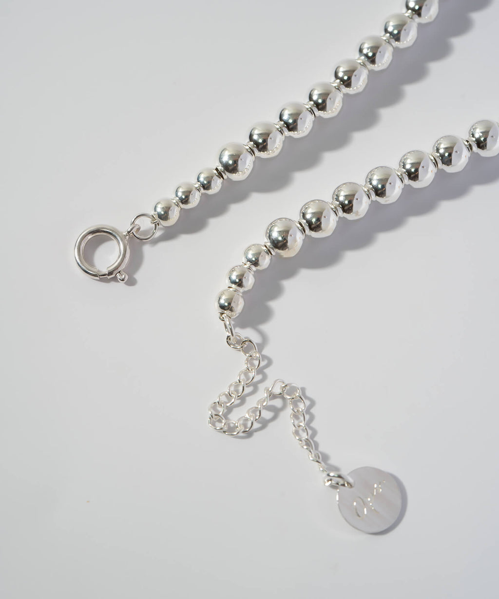 Clasp, adjuster chain and logo tag detail