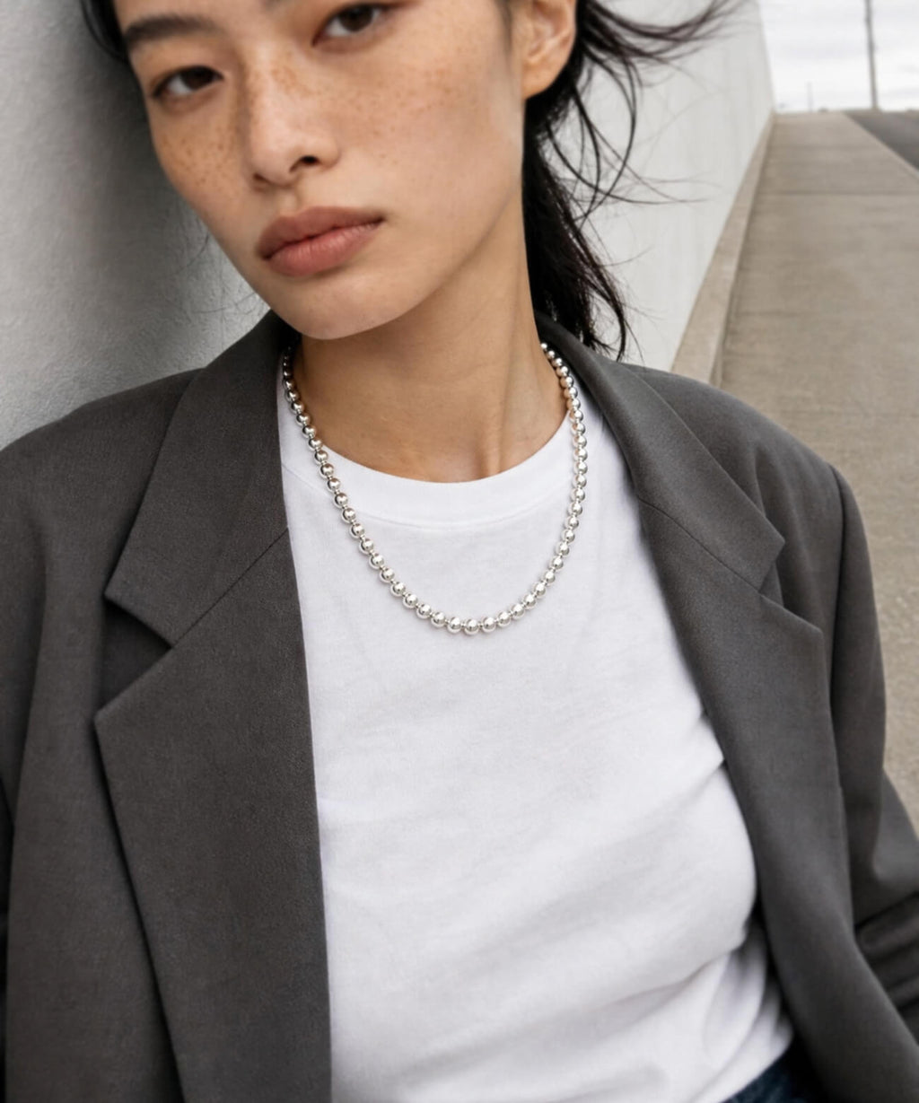 Sterling silver ball chain necklace with a jacket and white T-shirt