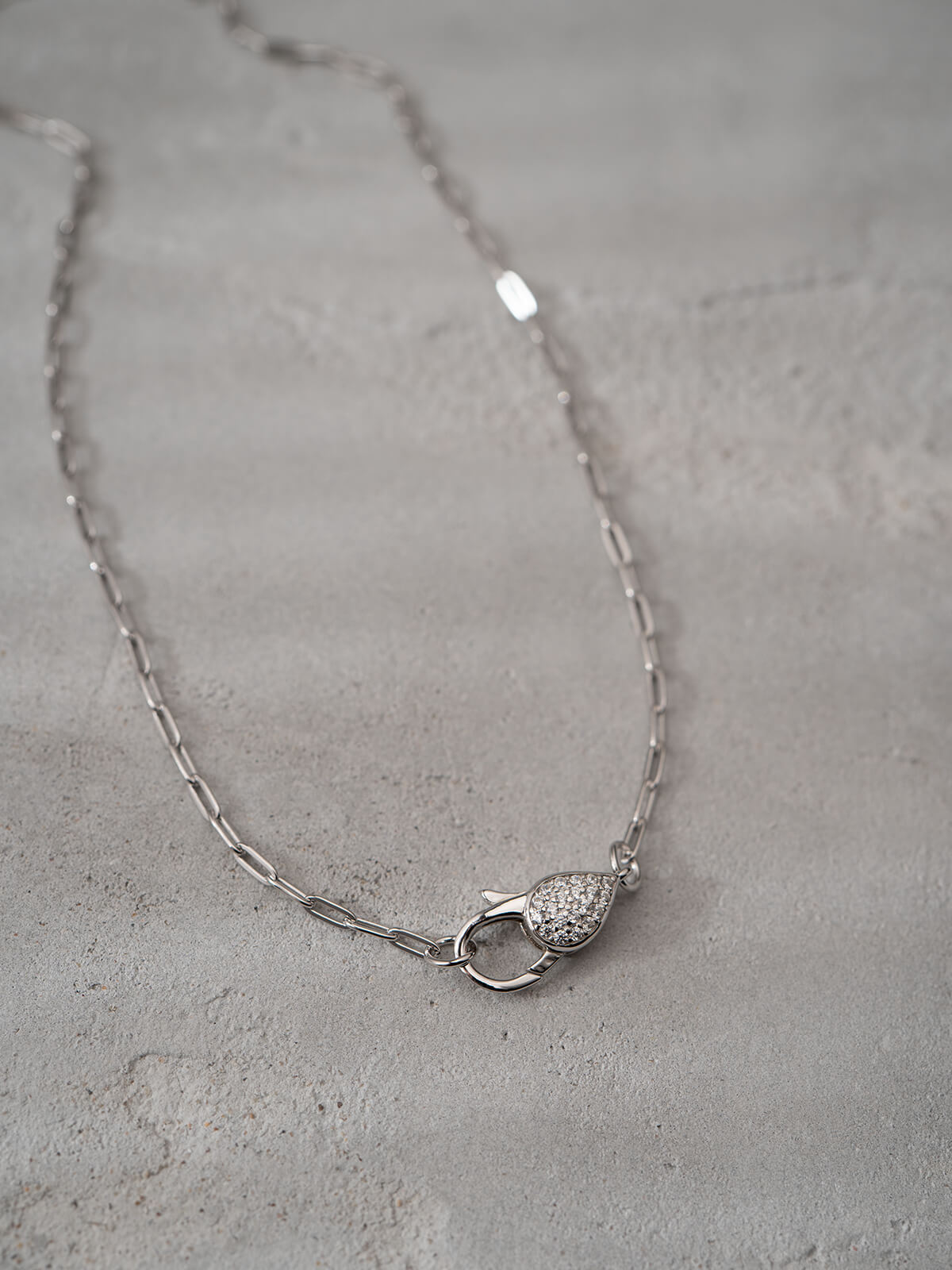 Silver paperclip chain choker necklace styled flat lay