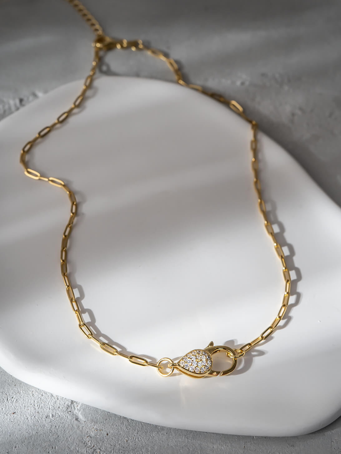 Light gold paperclip chain choker necklace styled flat lay