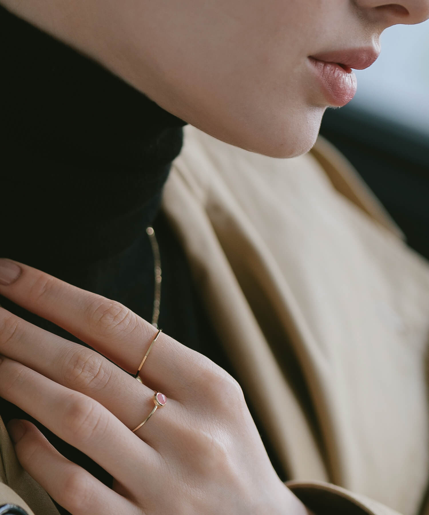 18K gold decagon skinny ring worn with a beige coat