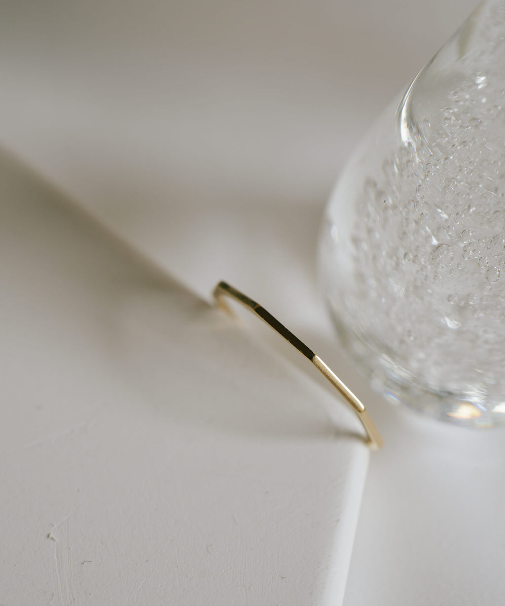 Close up of the faceted edge of the 18K gold skinny ring