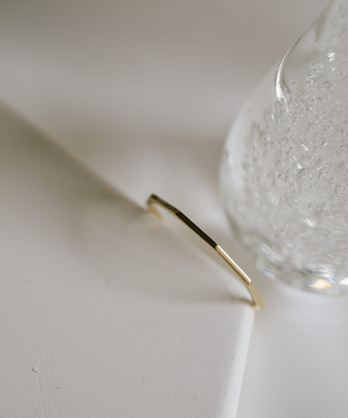 Close up of the faceted edge of the 18K gold skinny ring