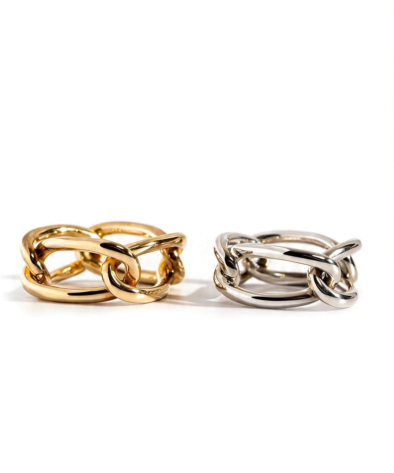 Silver and gold chunky chain rings on a white background