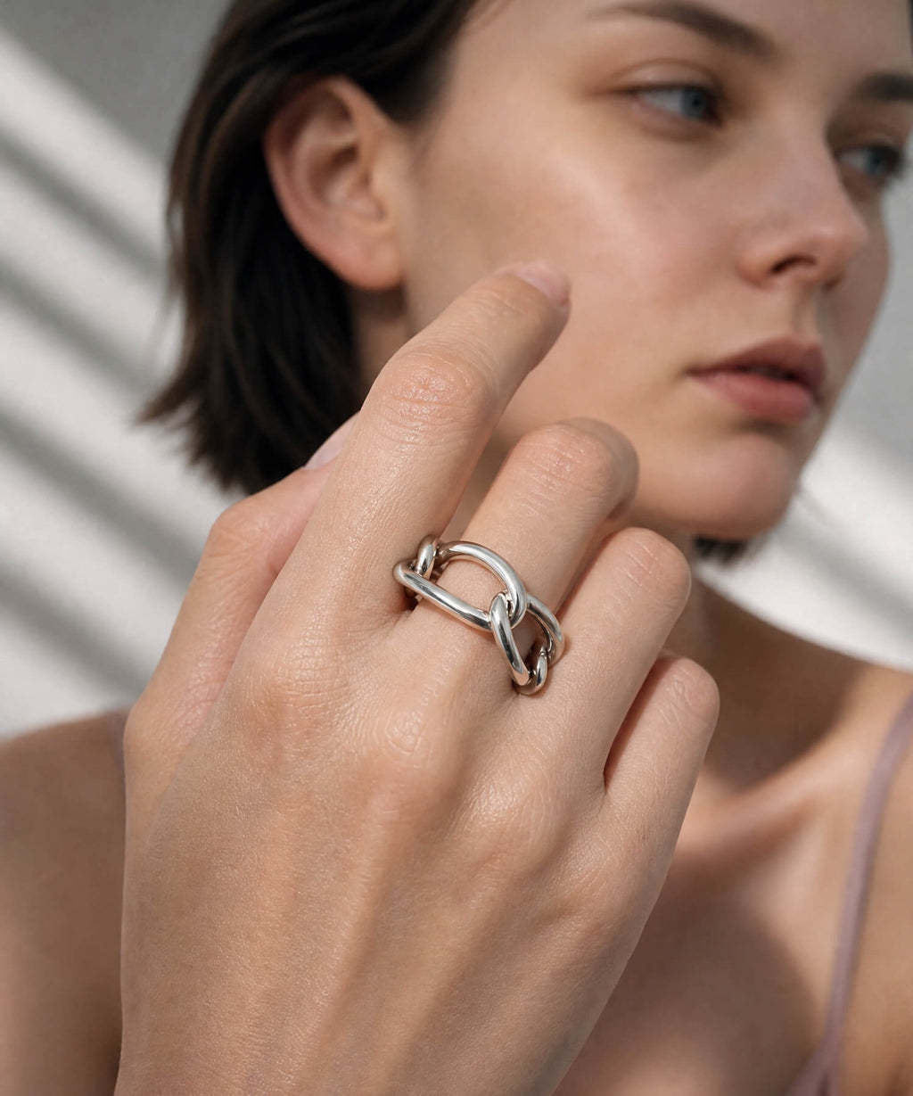 Close up of a hand wearing the sterling silver chunky chain ring beside the face