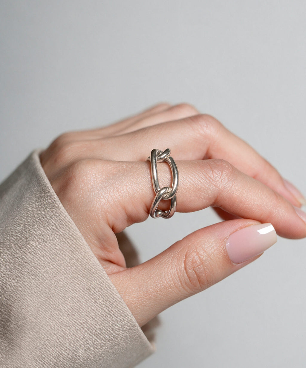 Hand resting on a linen sleeve wearing the sterling silver chunky chain ring