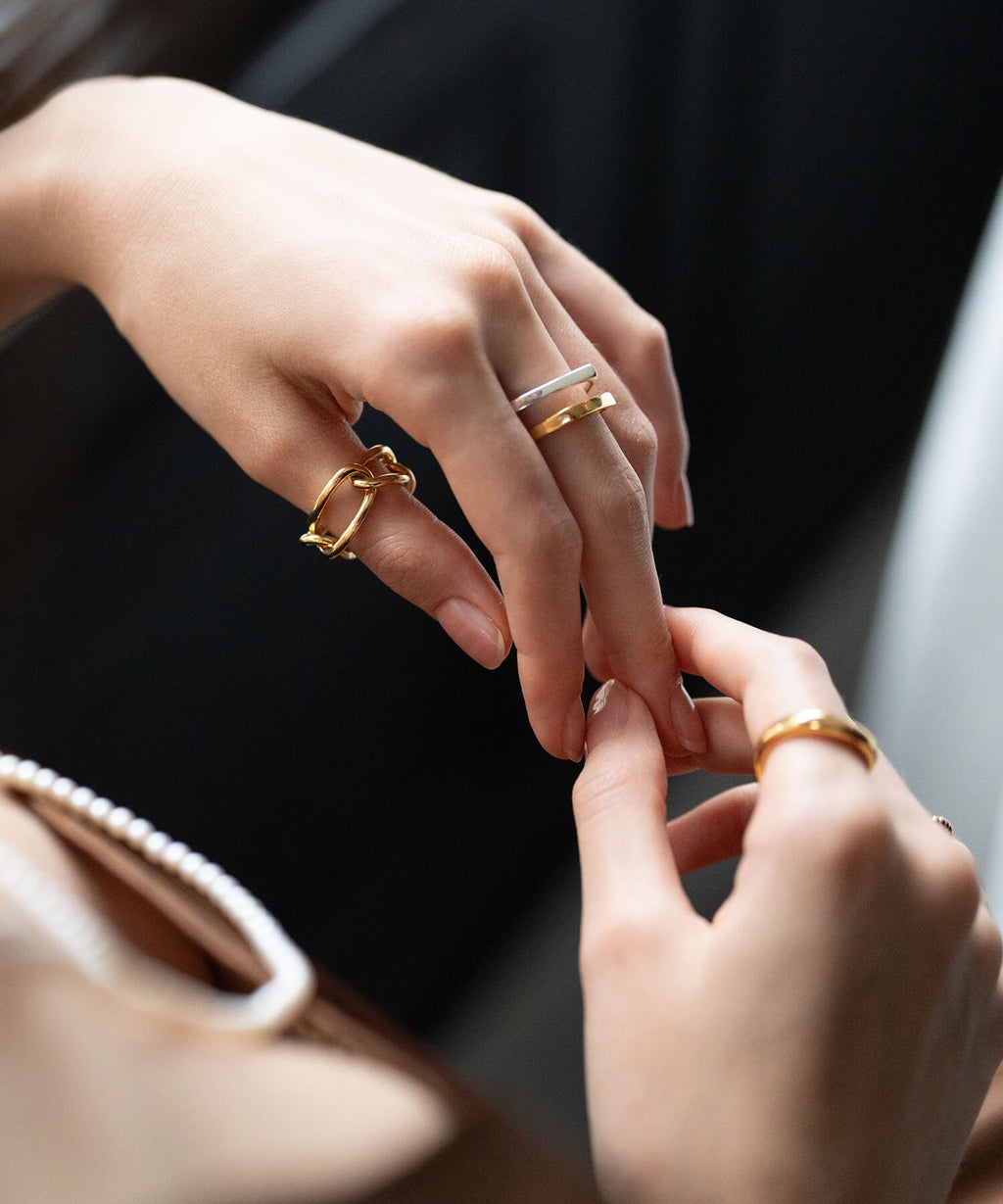 Hand holding a bag while wearing the 18K gold plated chunky chain ring